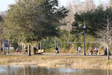 Visitors playing volleyball near lake