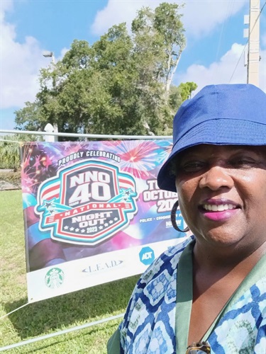 City resident taking a seflie in front of an NNO banner on a fence