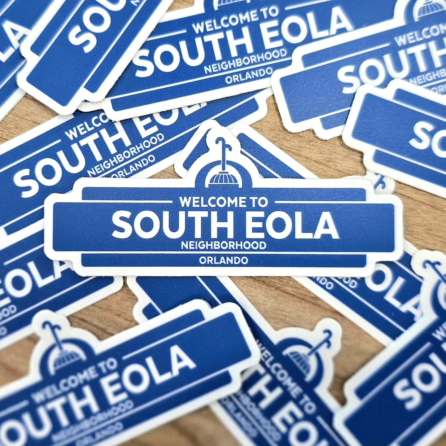 Blue and white stickers of the South Eola Neighborhood welcome sign