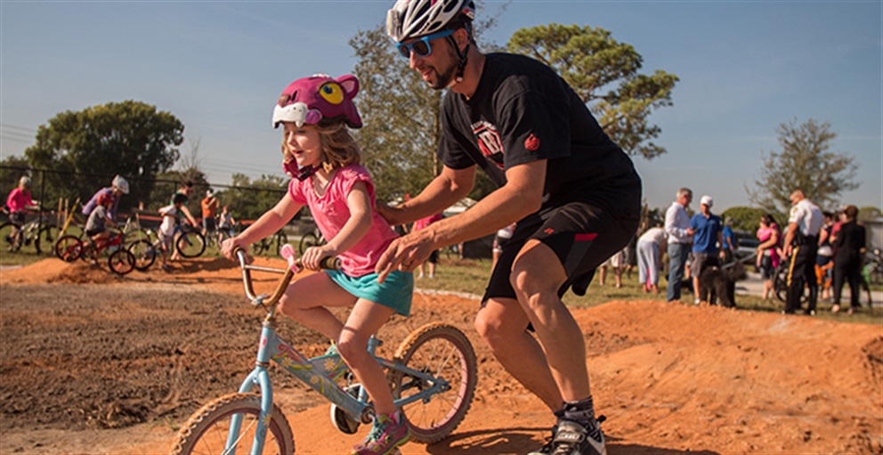 Kid on a Bike with an Adult Helping at Lake Druid Park