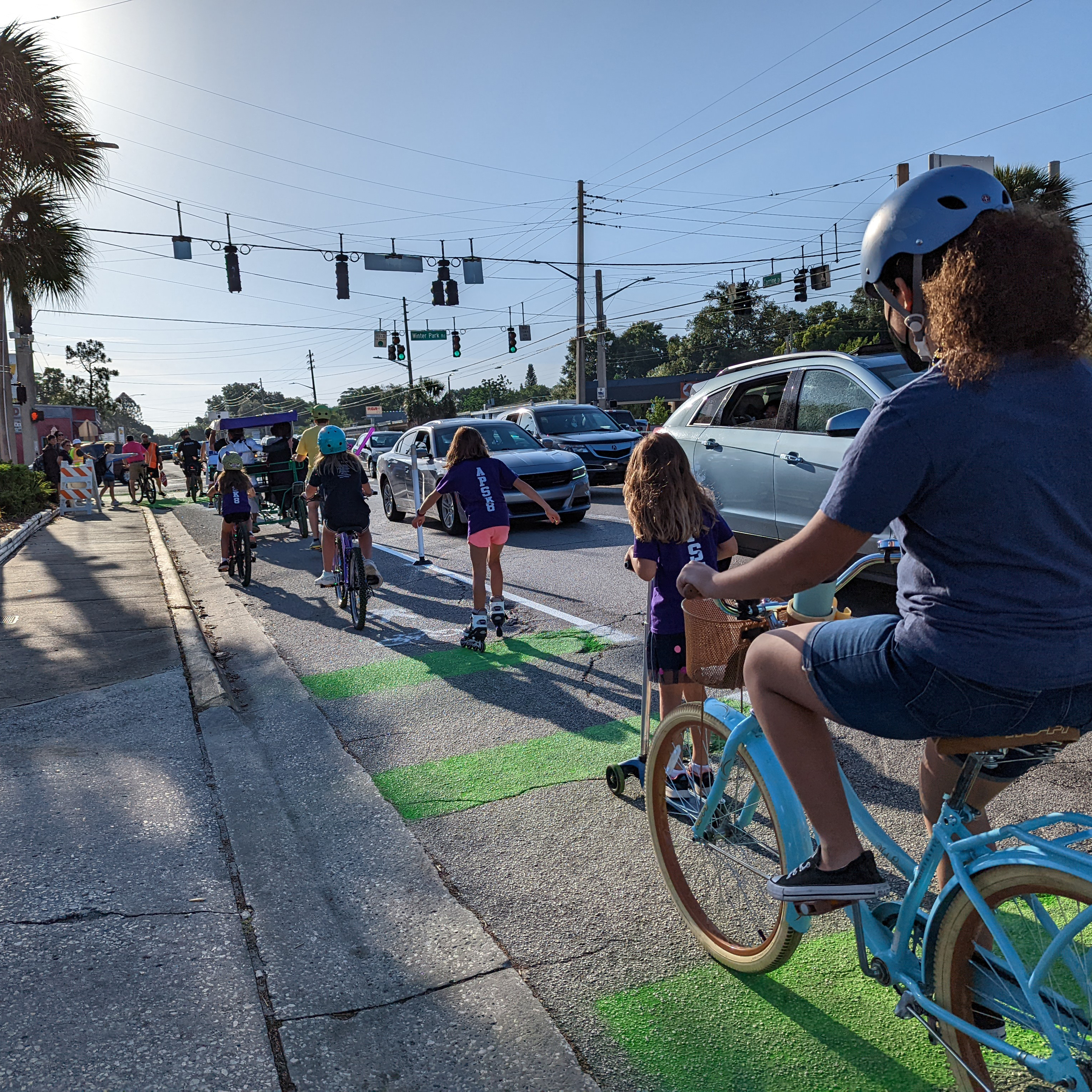 Photograph of children biking along a quick-build bicycle lane.