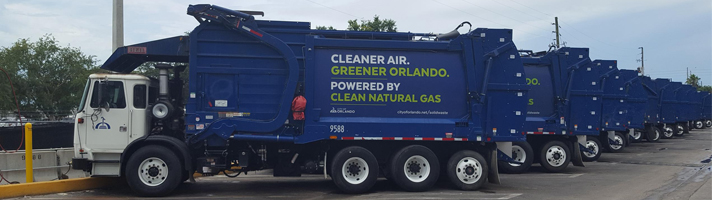 Fleet of Orlando solid waste trucks with the following motto on the sides: Cleaner Air. Greener Orlando. Powered by Clean Natural Gas